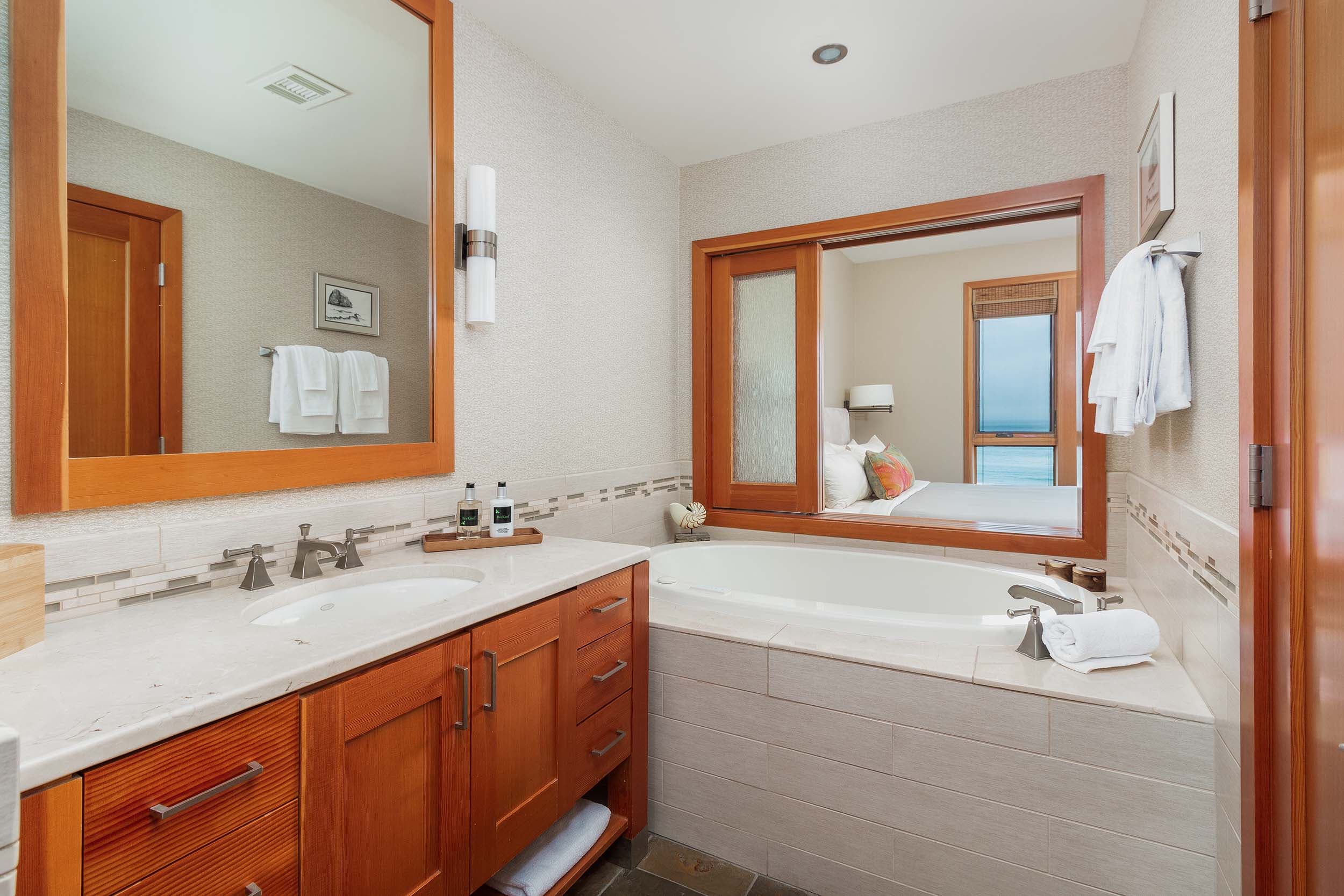A washroom with a vanity and tub in a 2 Bedroom Cottage at Headlands