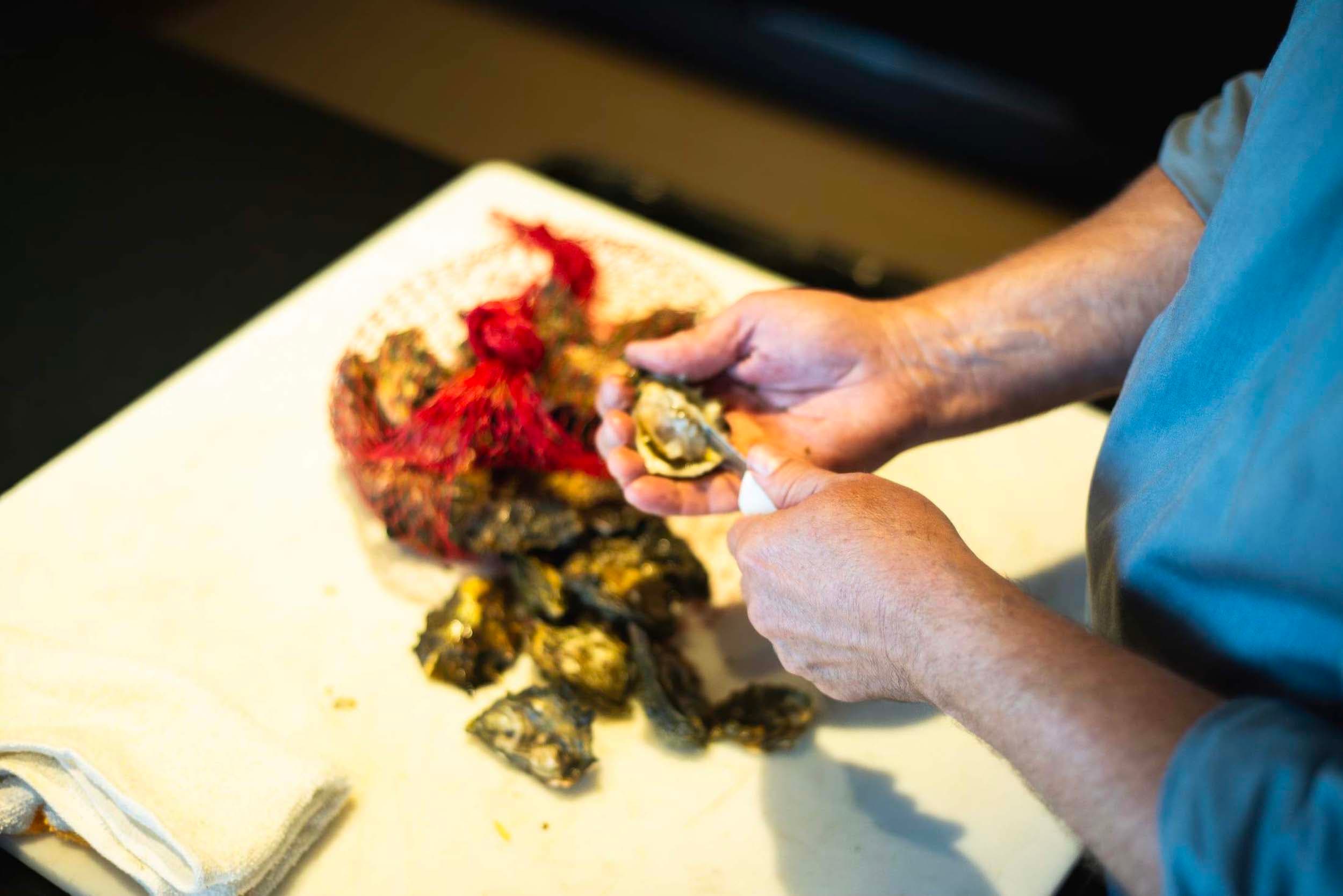 A man shucking oysters at Meridian restaurant