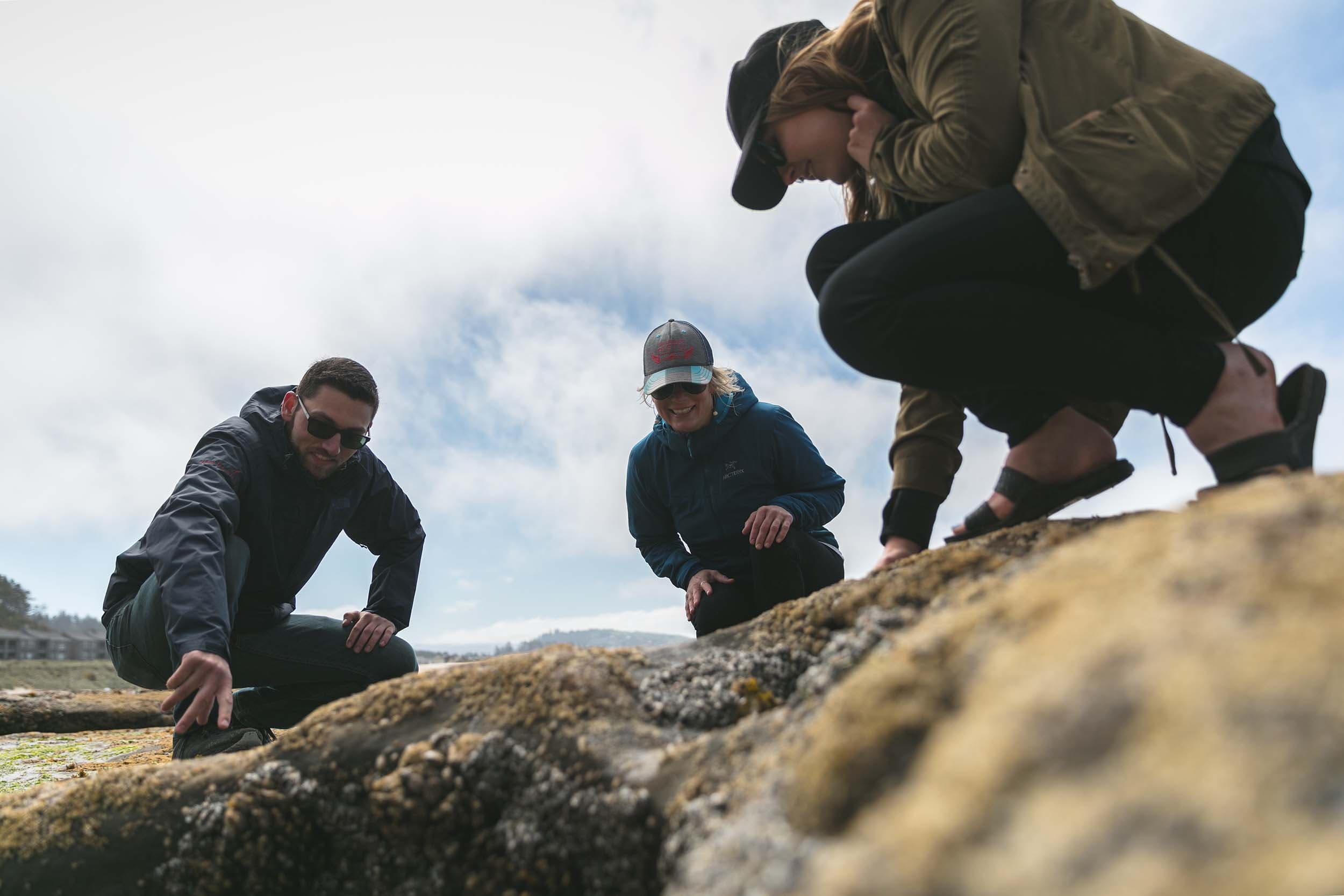 3 people exploring the tide pools at Cape Kiwanda