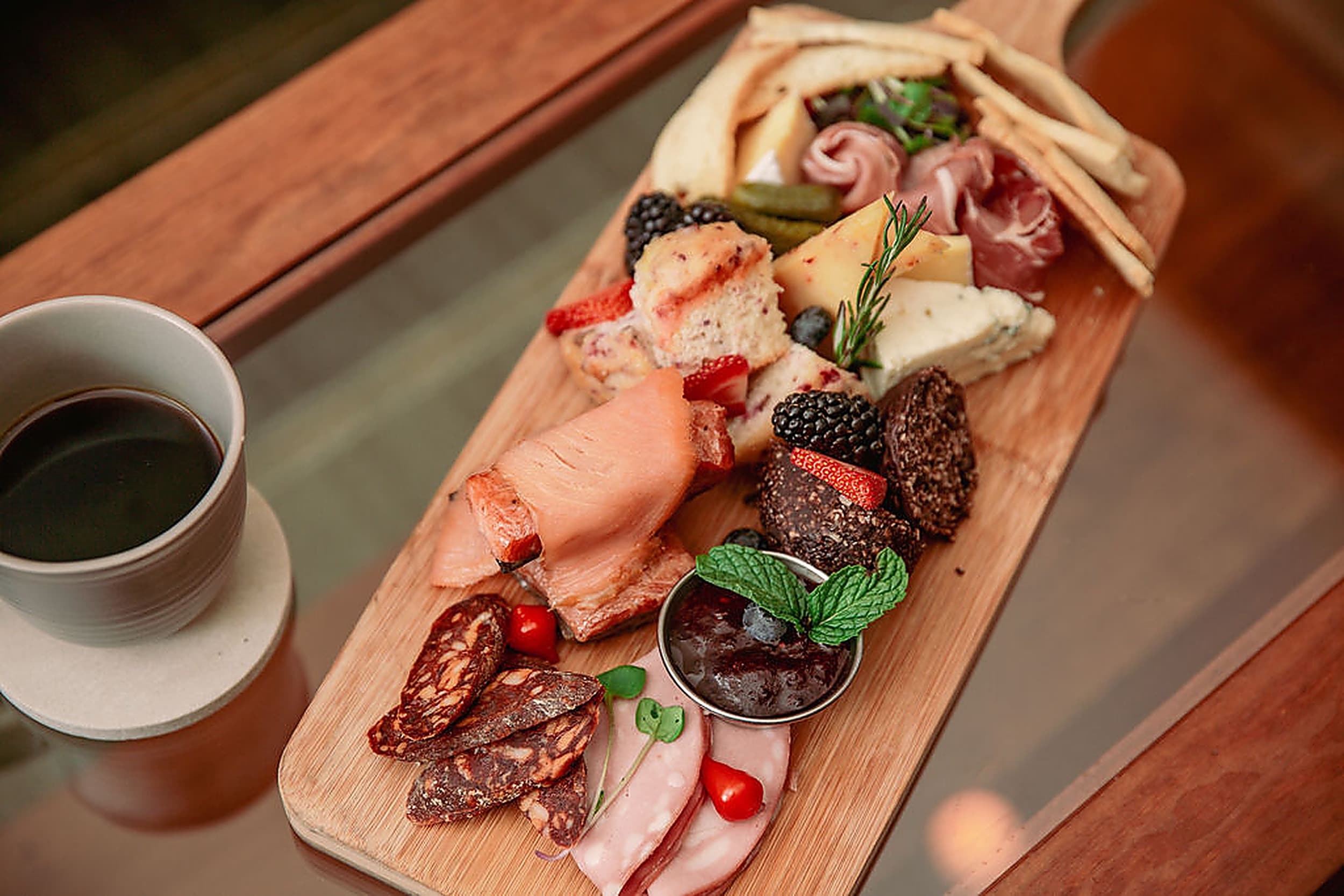 Artisan charcuterie board with cured meats, cheeses and berries beside coffee at Headlands Coastal Lodge & Spa, Pacific City Oregon