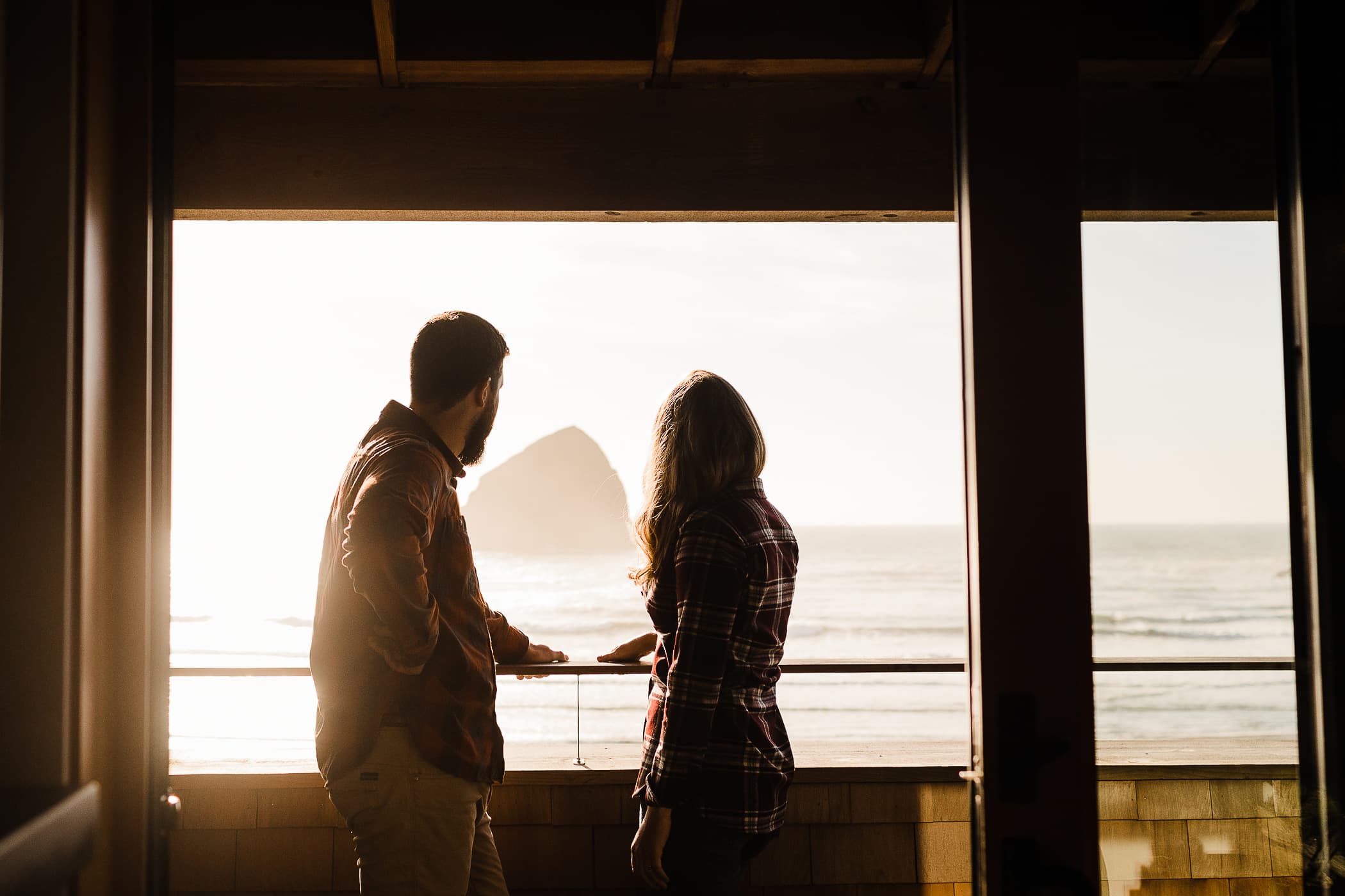 Couple Looking Out The Window At The Ocean