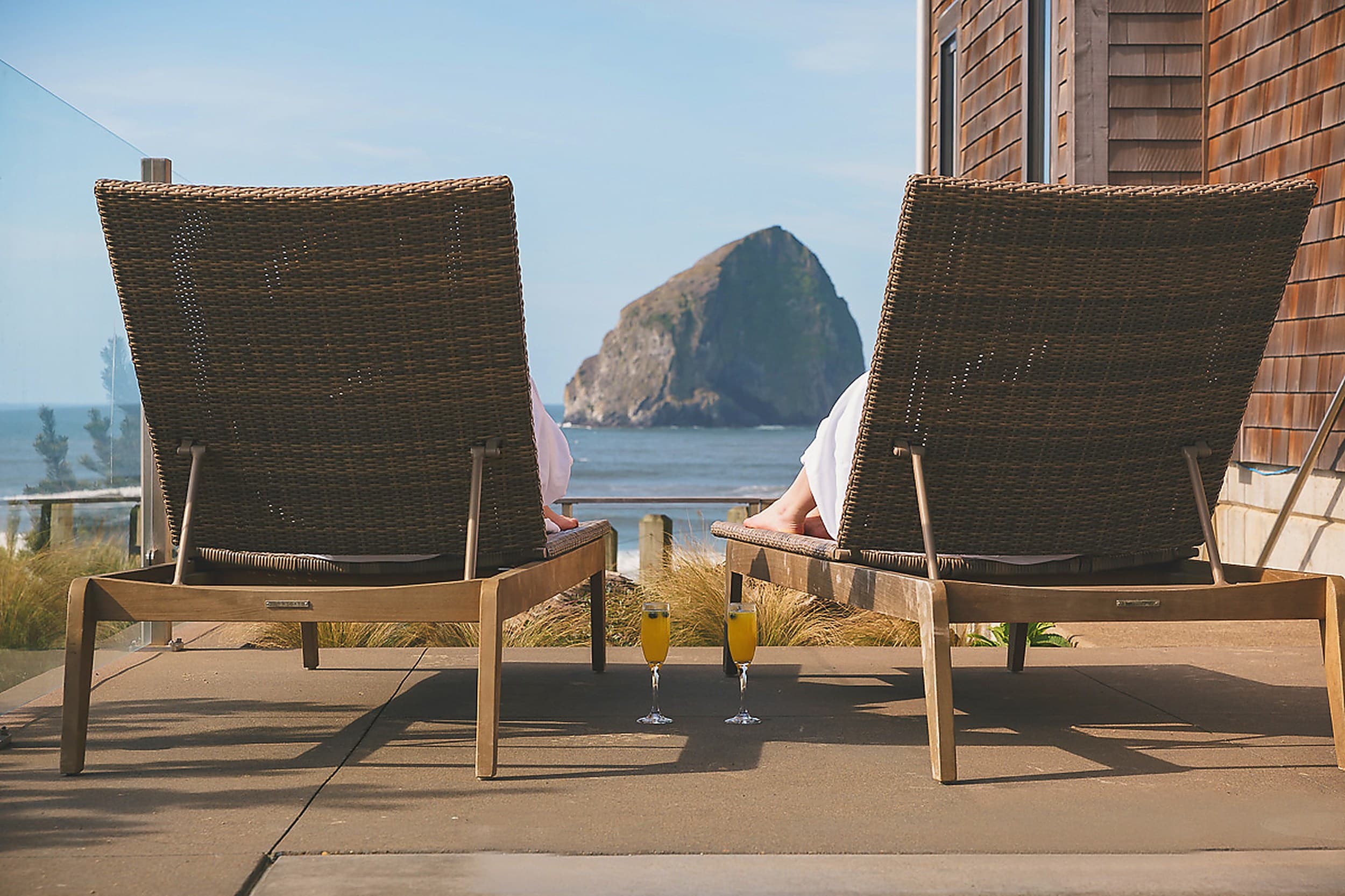 Oceanfront lounge chairs with mimosas overlooking Haystack Rock at Headlands Coastal Lodge & Spa in Pacific City, Oregon