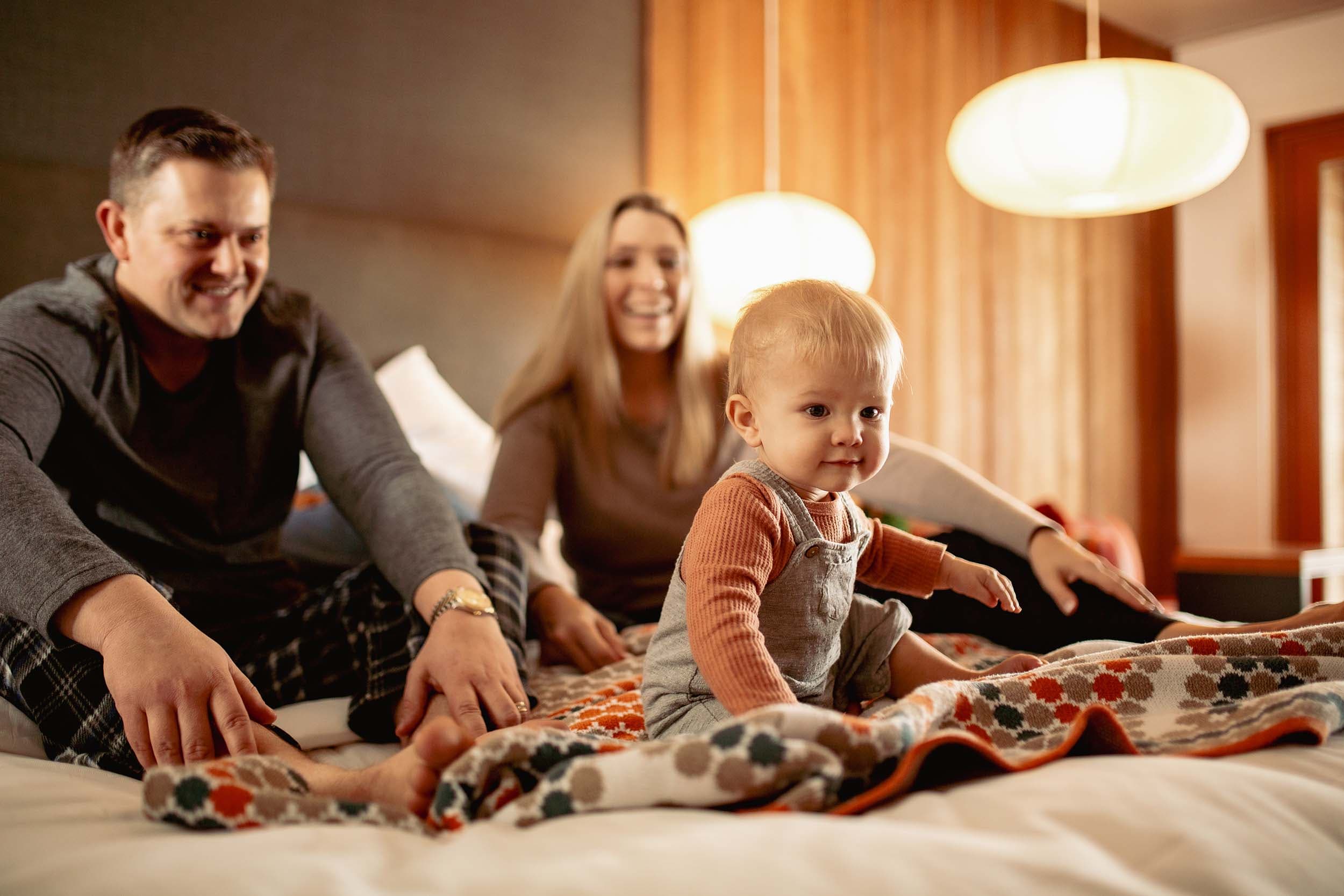 A family sitting on the bed in their room at Headlands