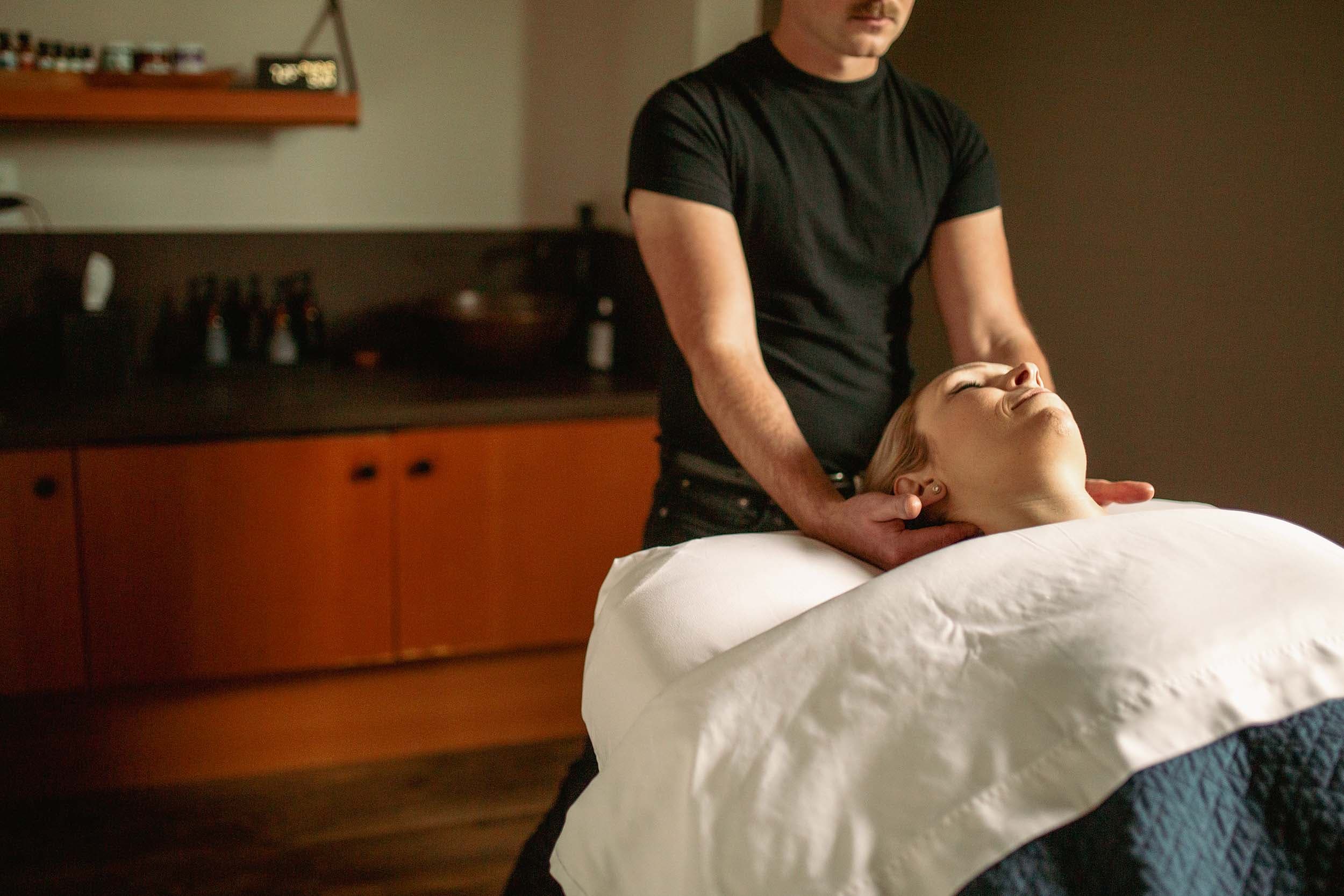 A woman laying in a massage bed at the spa at Headlands