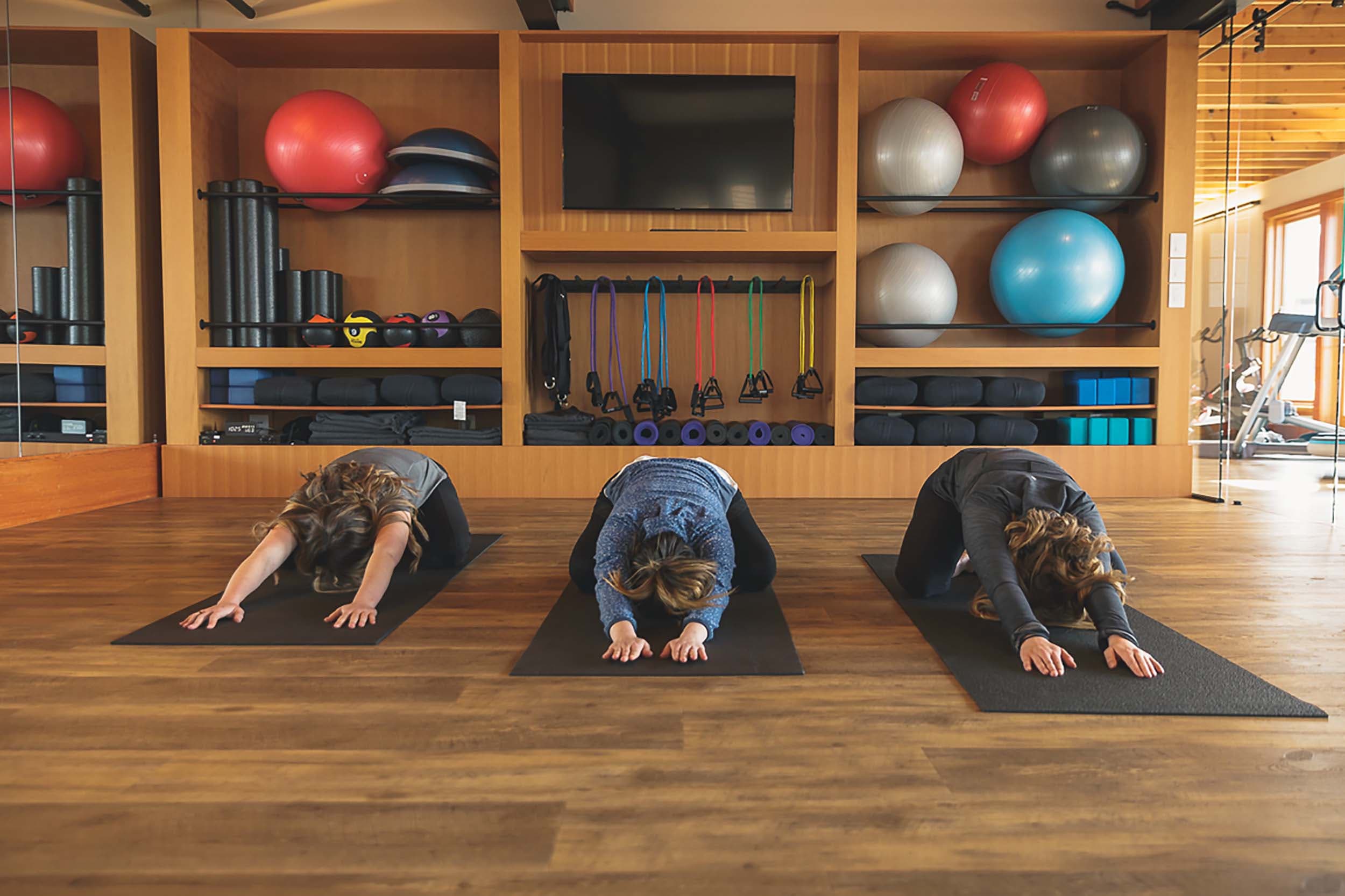 3 people doing yoga at the Wellness Studio at Headlands