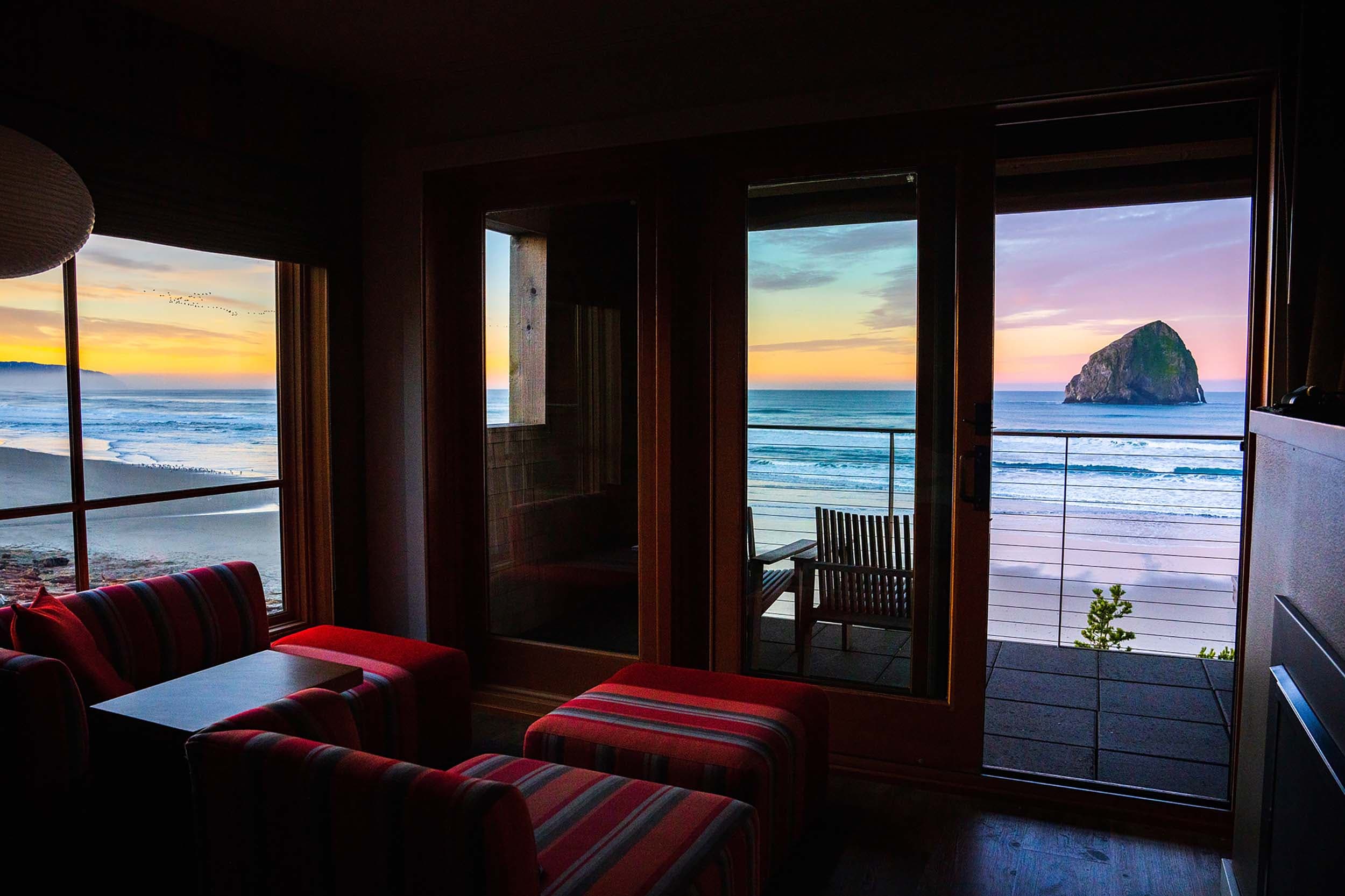 A darkened room during sunset with a view of Haystack rock at Headlands