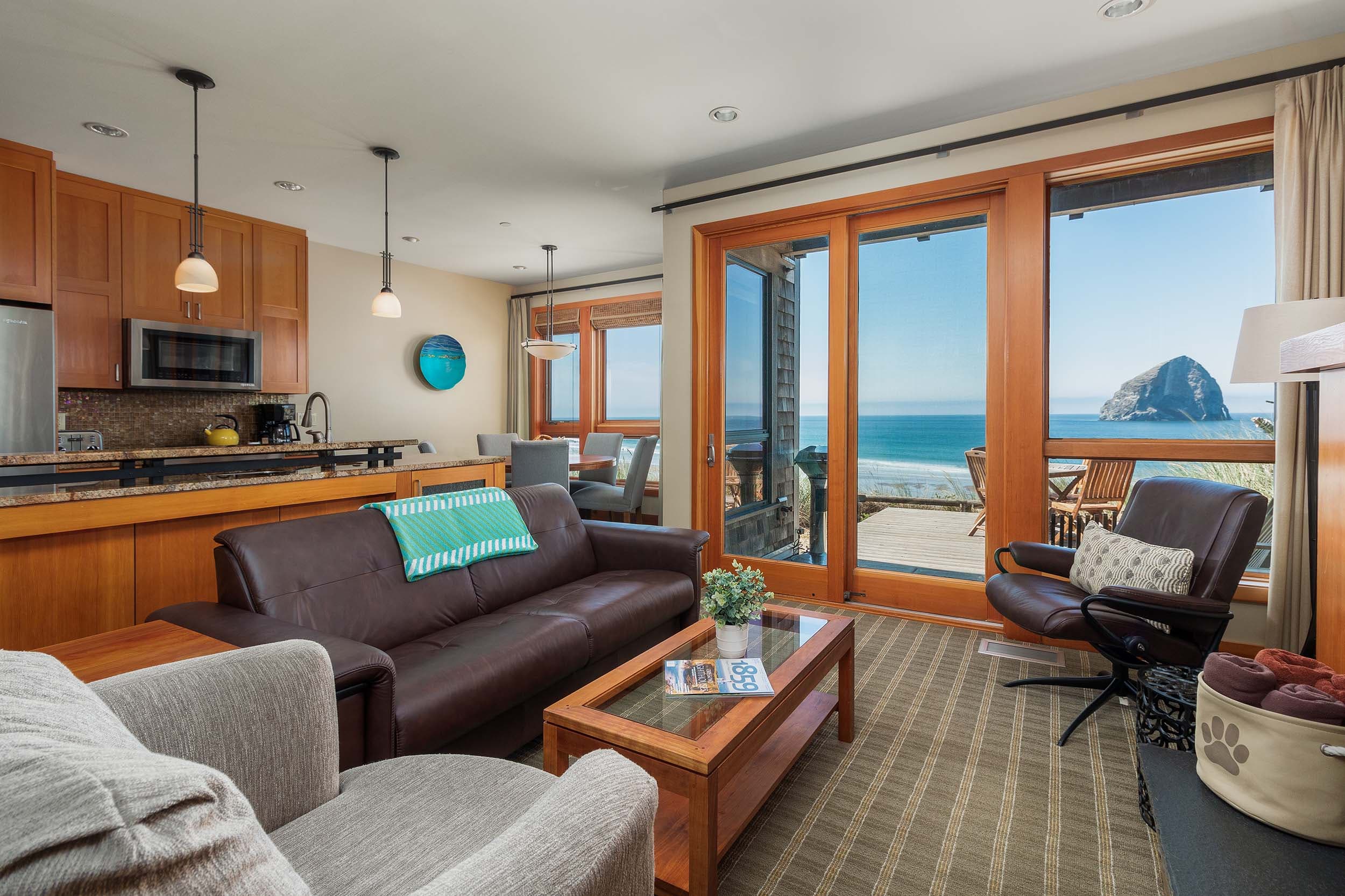 The living space with a couch, rocker and a view of Haystack rock in a 3 grand bedroom cottage at Headlands