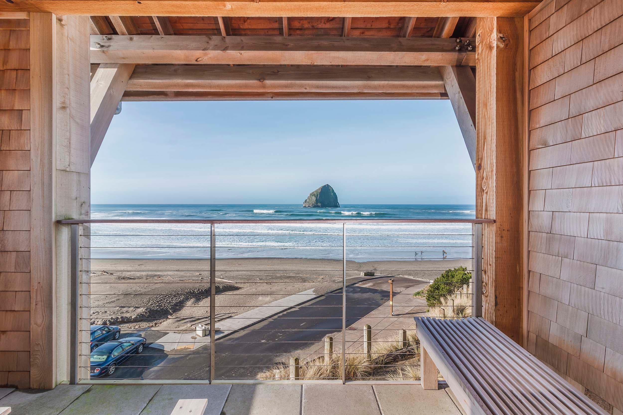 A balcony with a view of Haystack rock from a Corner King Sunlight Accessible at Headlands