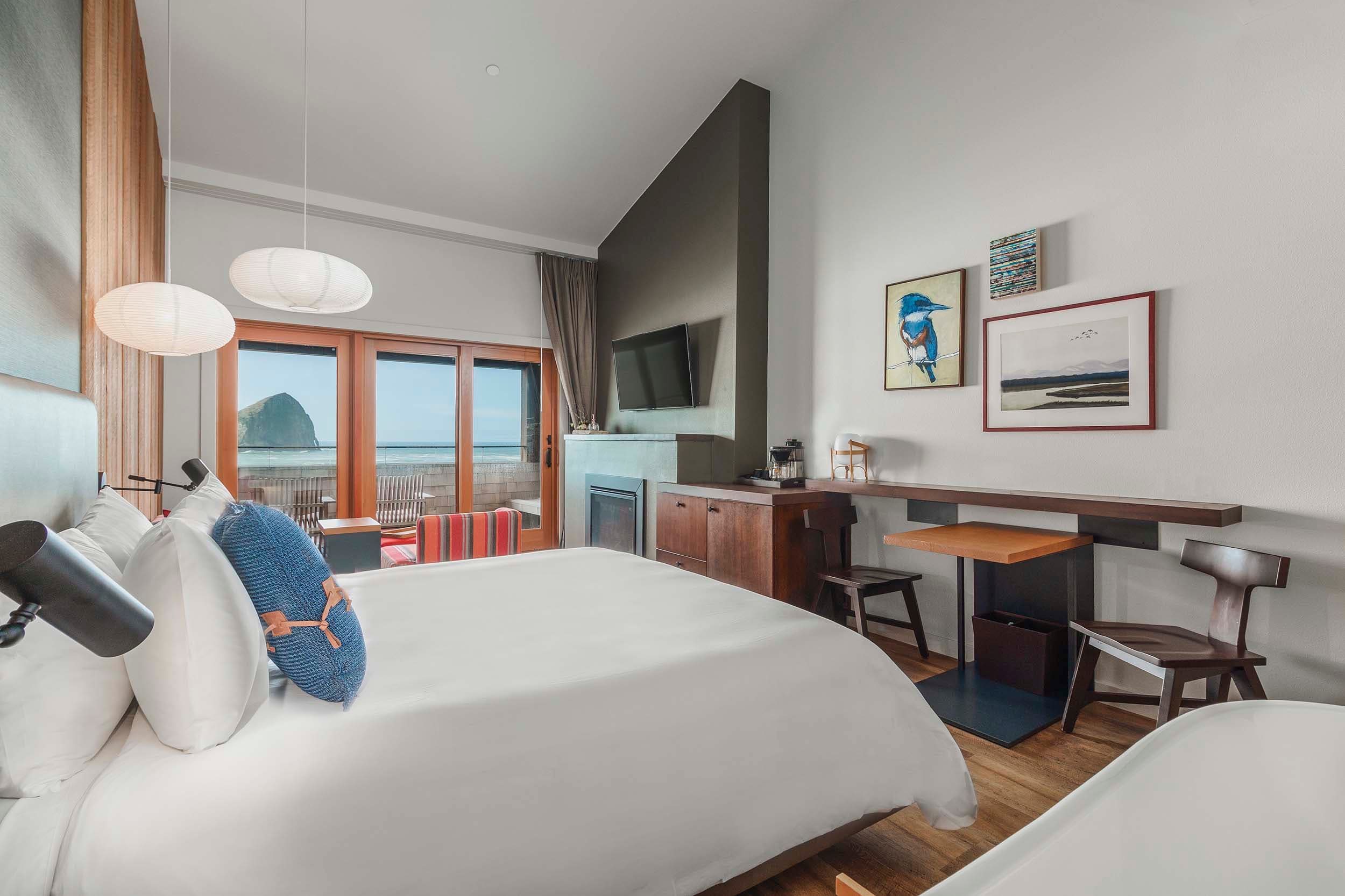 A King Top Floor room at Headlands with a king bed, desk, fireplace and a gorgeous view of the ocean and Haystack rock