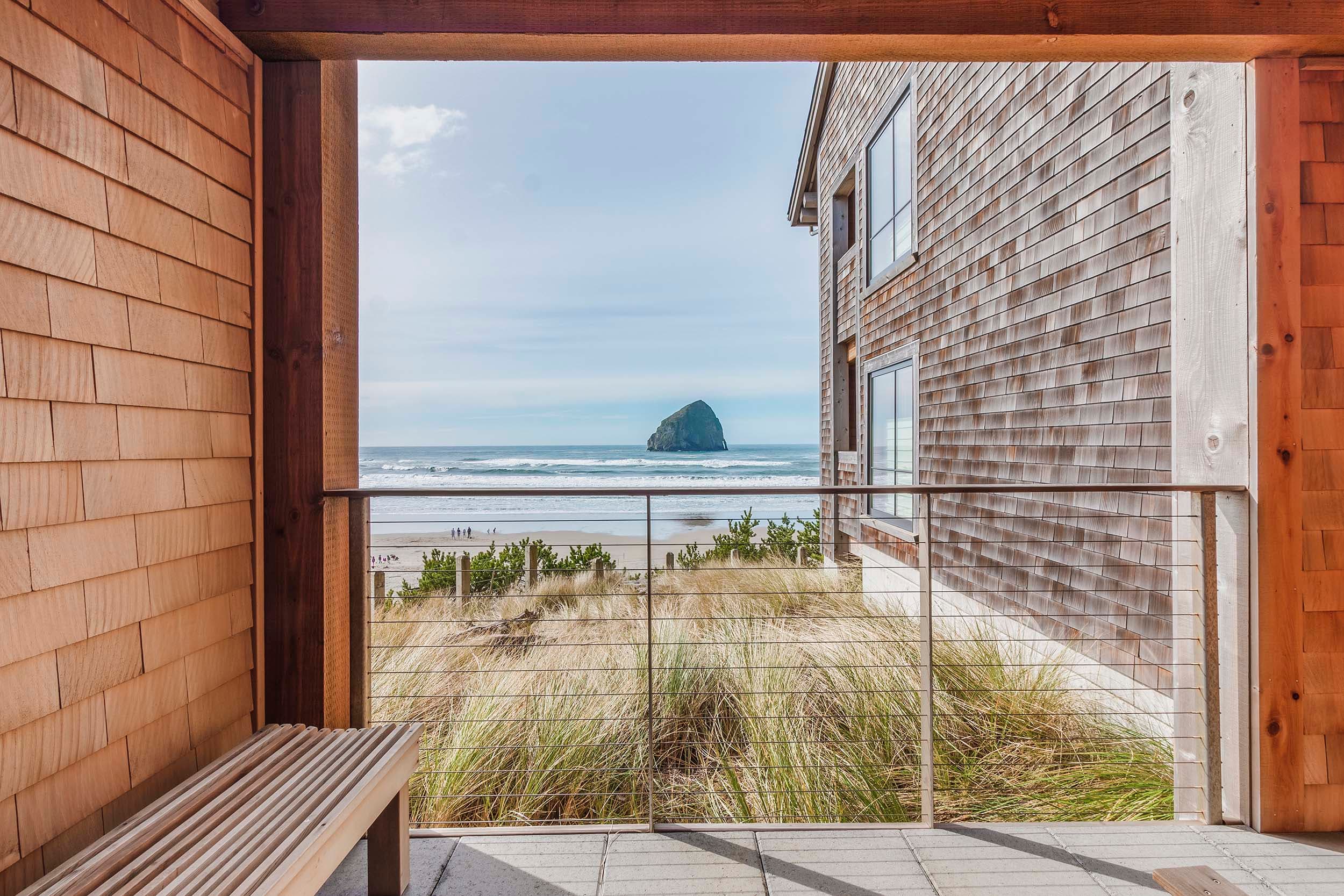 A balcony with a bench and view of haystack rock from a King Signature room in the Oceanfront lodge at Headlands