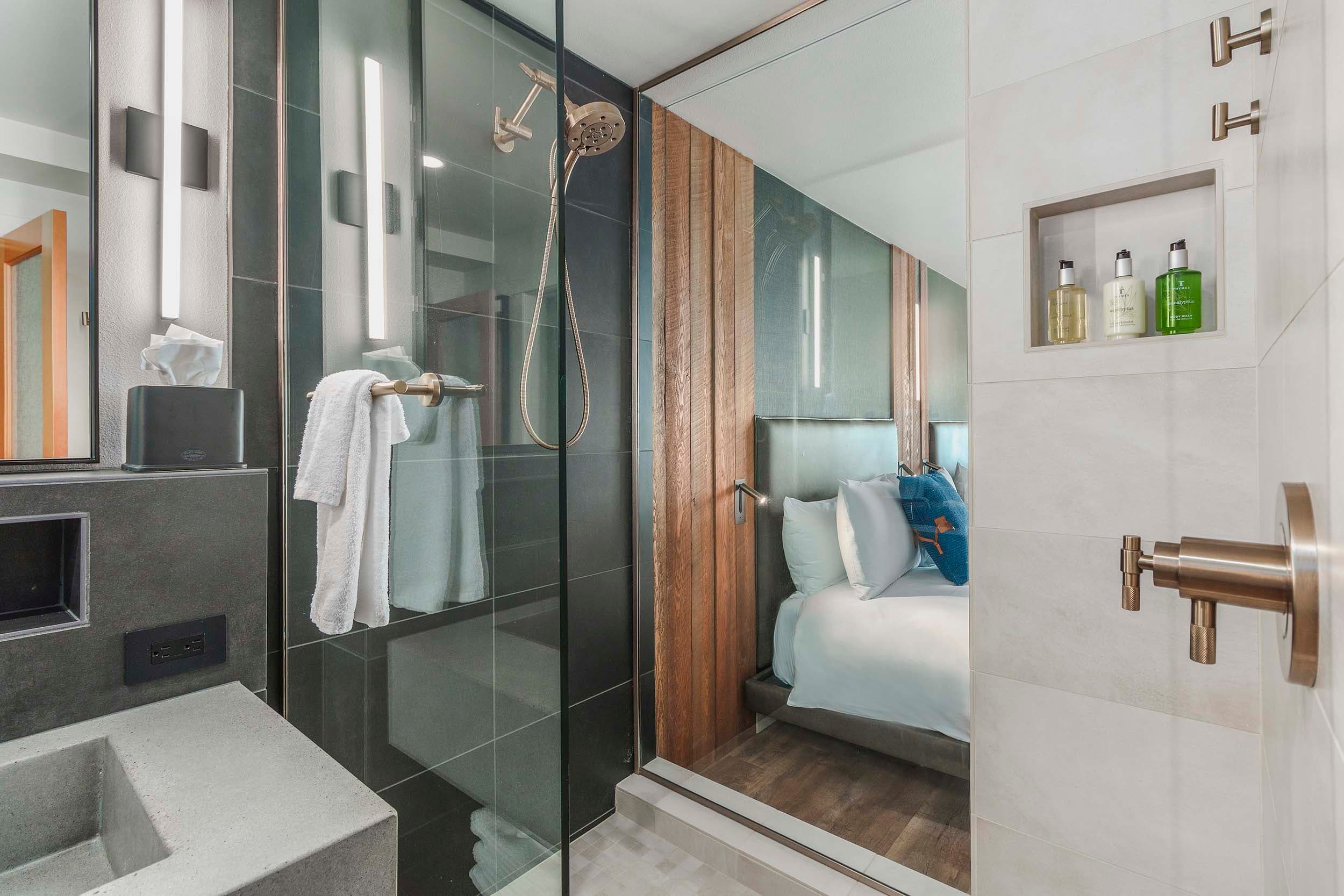 A modern bathroom with bright lighting and a glass shower in a Two Queens Sunlight lodge at Headlands