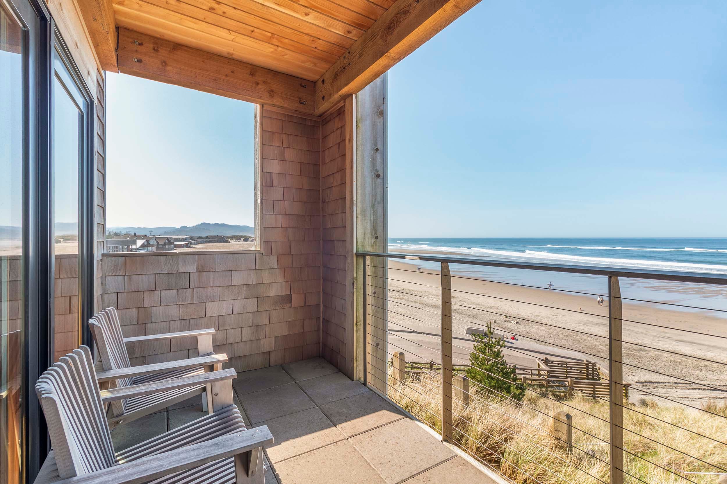 A balcony with two chairs and a view of the ocean from a King Sunlight at Headlands