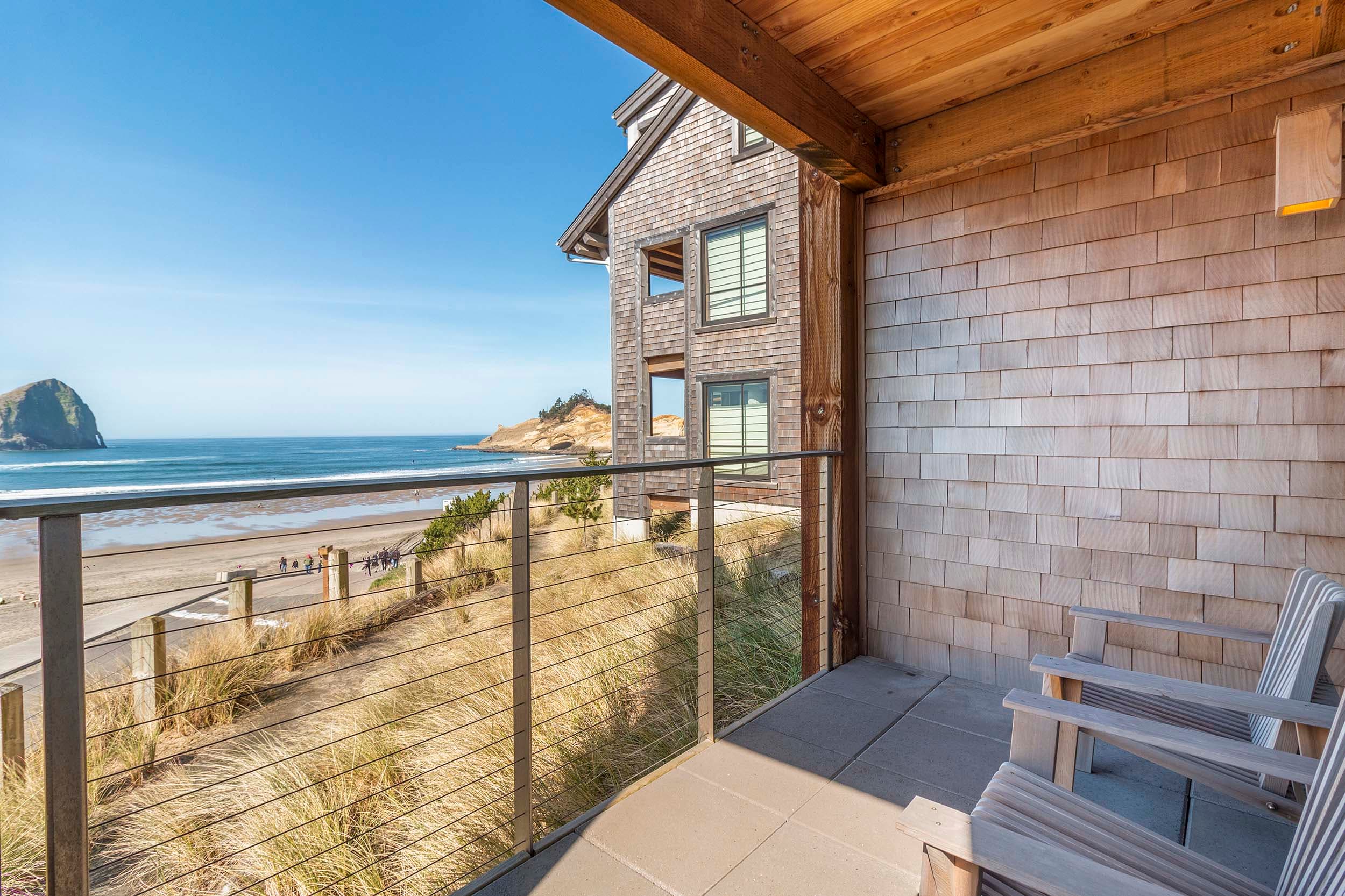 the balcony with a view of the ocean and Haystack rock in a King Sunlight Accessible room at Headlands