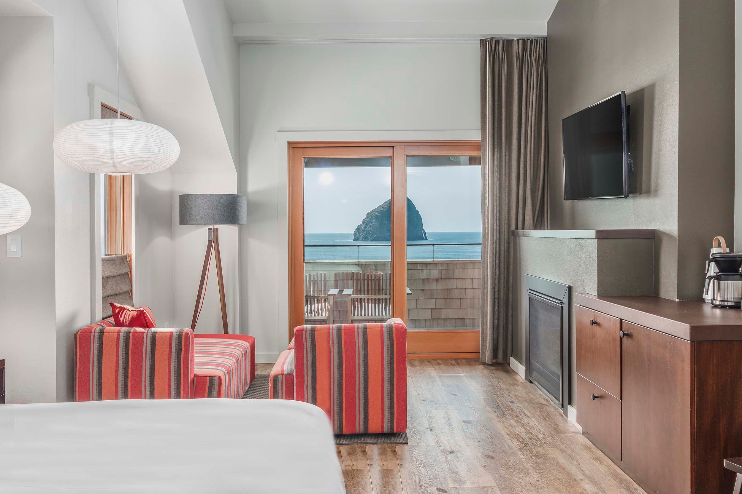 The cozy lounge area with a fireplace, access to the balcony and a great view of Haystack rock in a King Sunlight Top Floor at Headlands