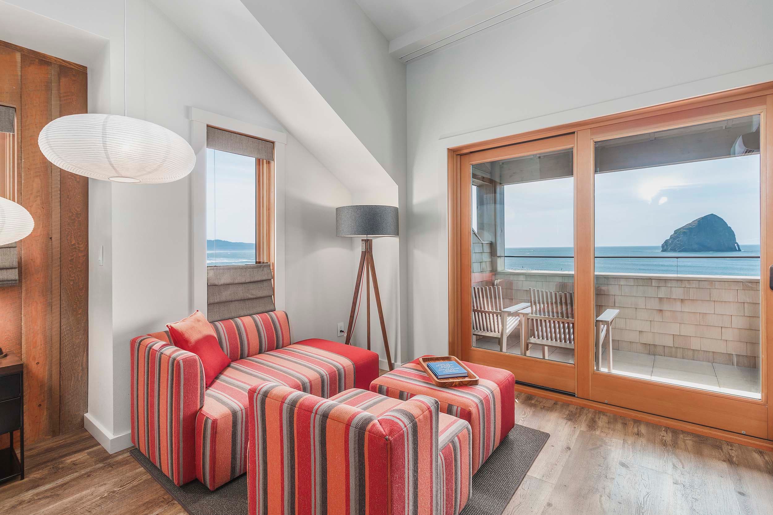 A lounge area with lots of windows looking onto the beach in a Two Queen Top Floor at Headlands