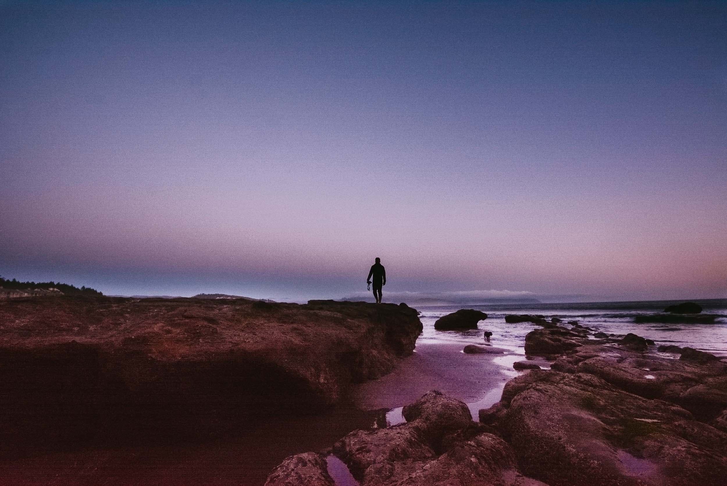 A person exploring the tide pools at night