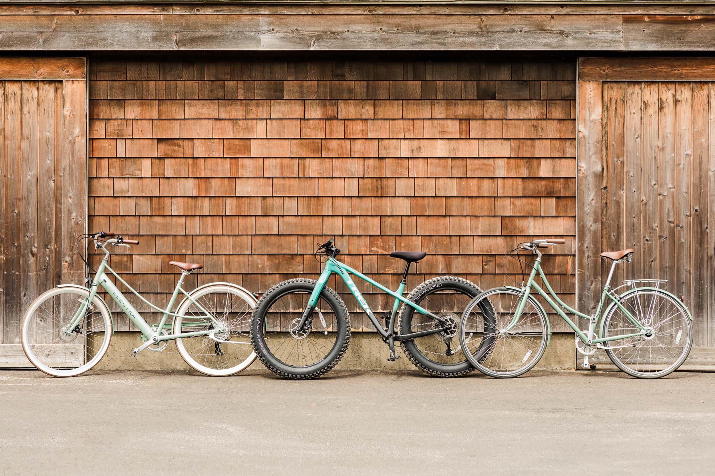 3 bikes leaning against a wood shingles building near Headlands