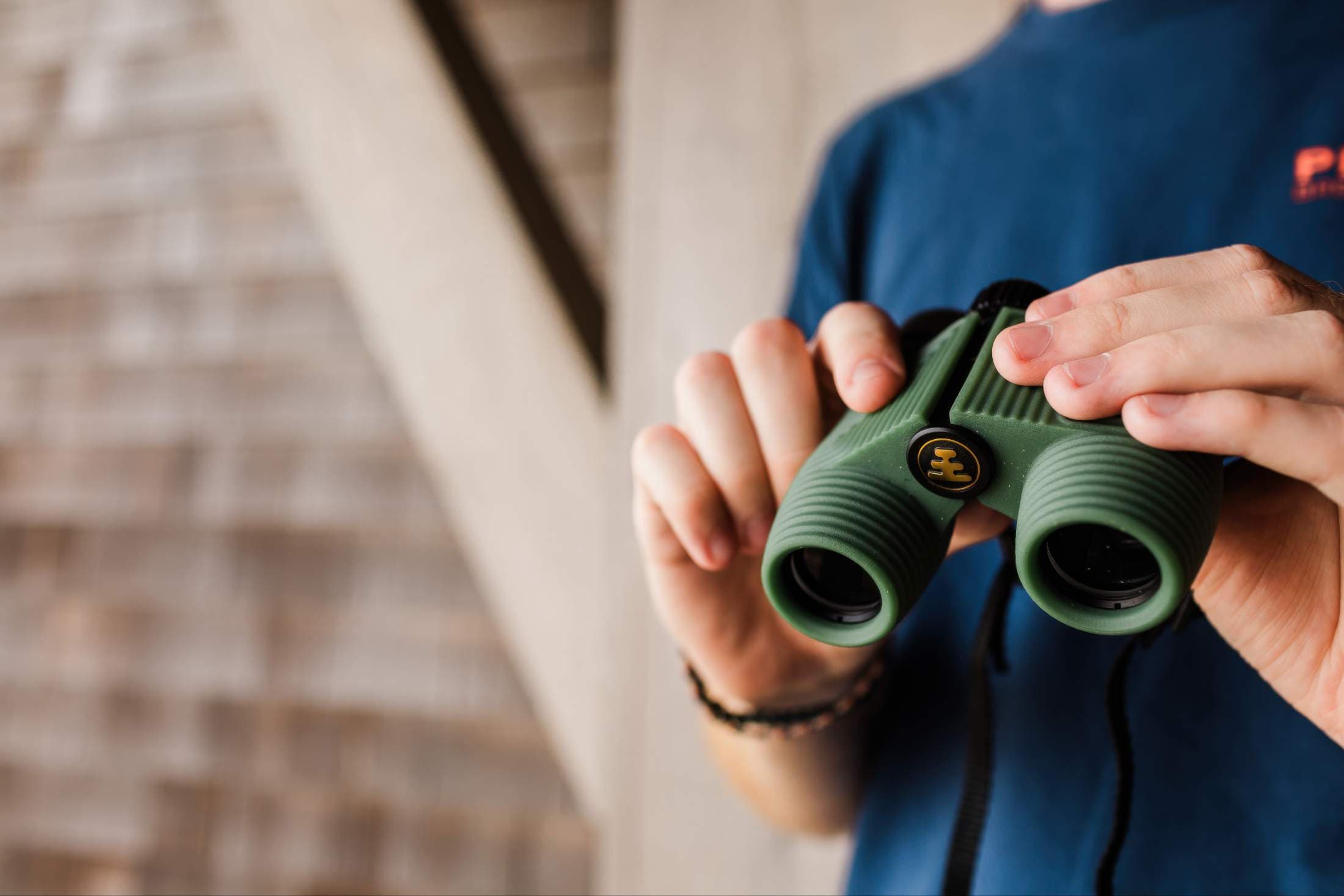 A man holding binoculars on a balcony at Headlands