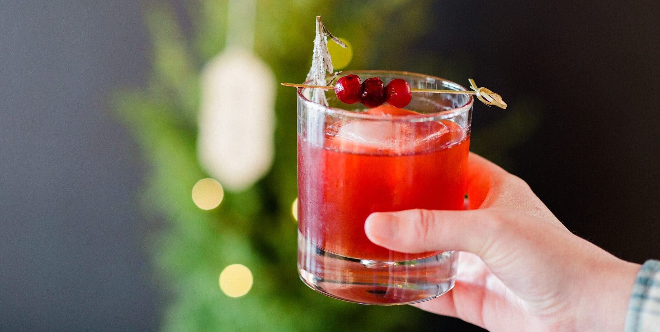 A hand holding a festive cocktail at Headlands