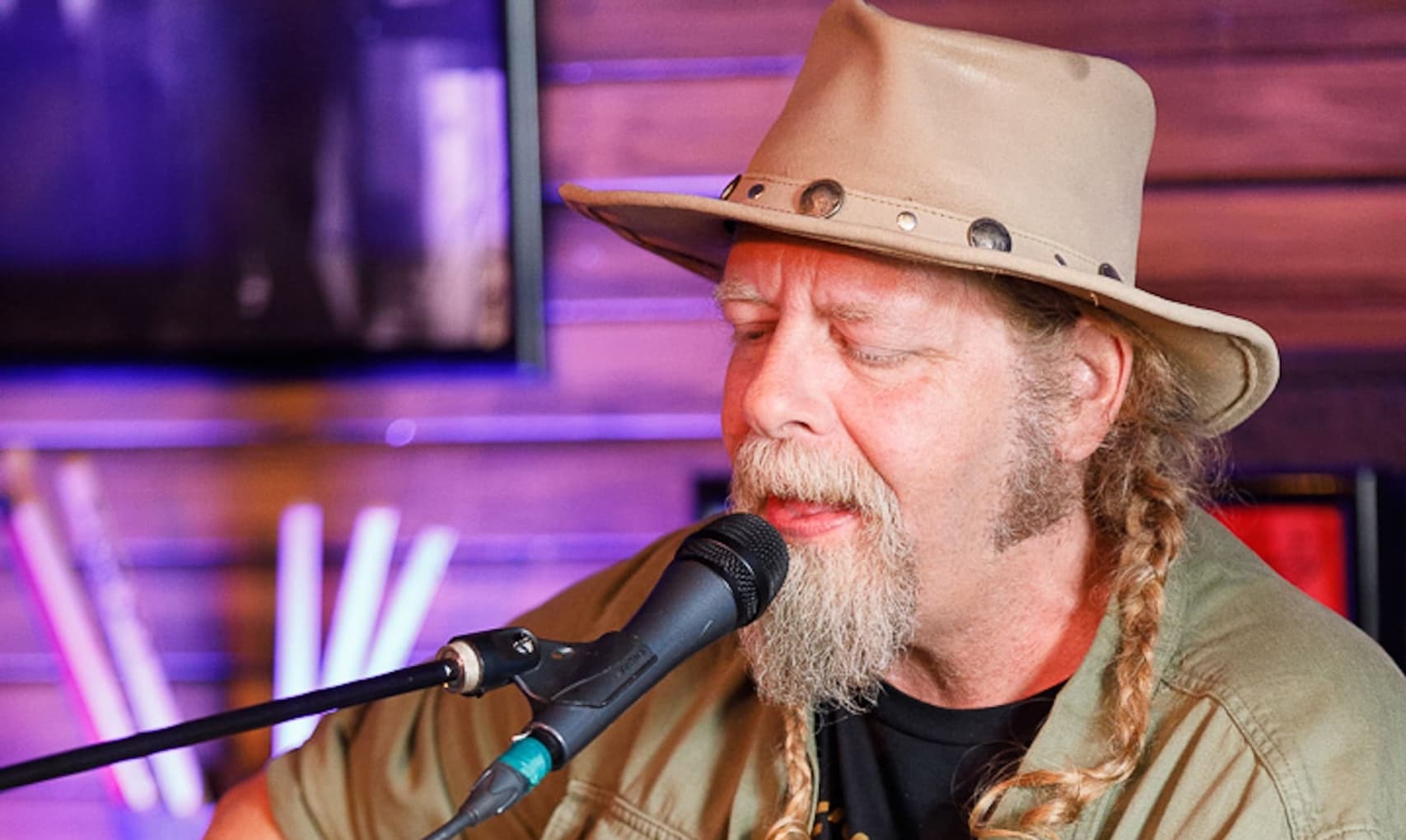 Kris Stuart playing guitar and singing on stage at Meridian Restaurant & Bar