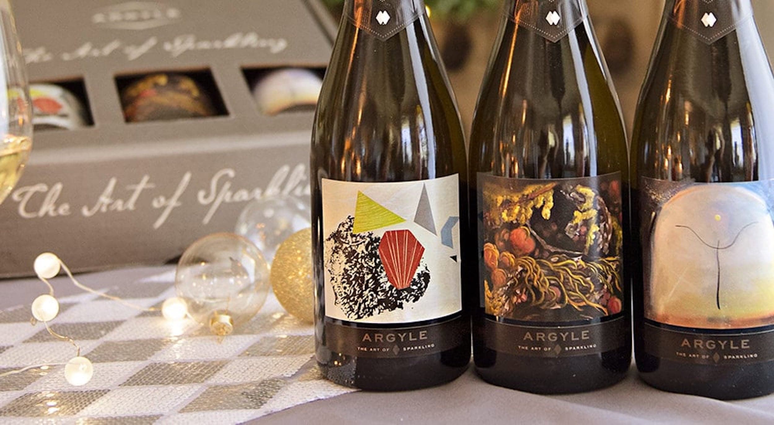 Three bottles of Argyle white wines displayed on a table with festive decorations