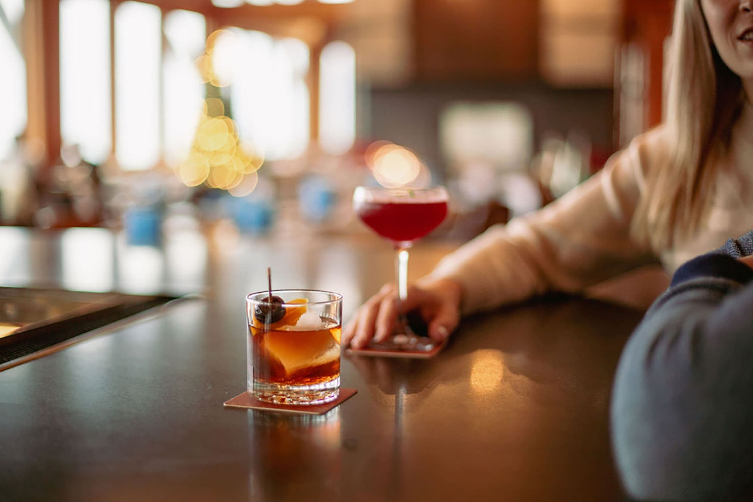 A couple sitting at the Meridian Restaurant bar engaging ion conversation having cocktails