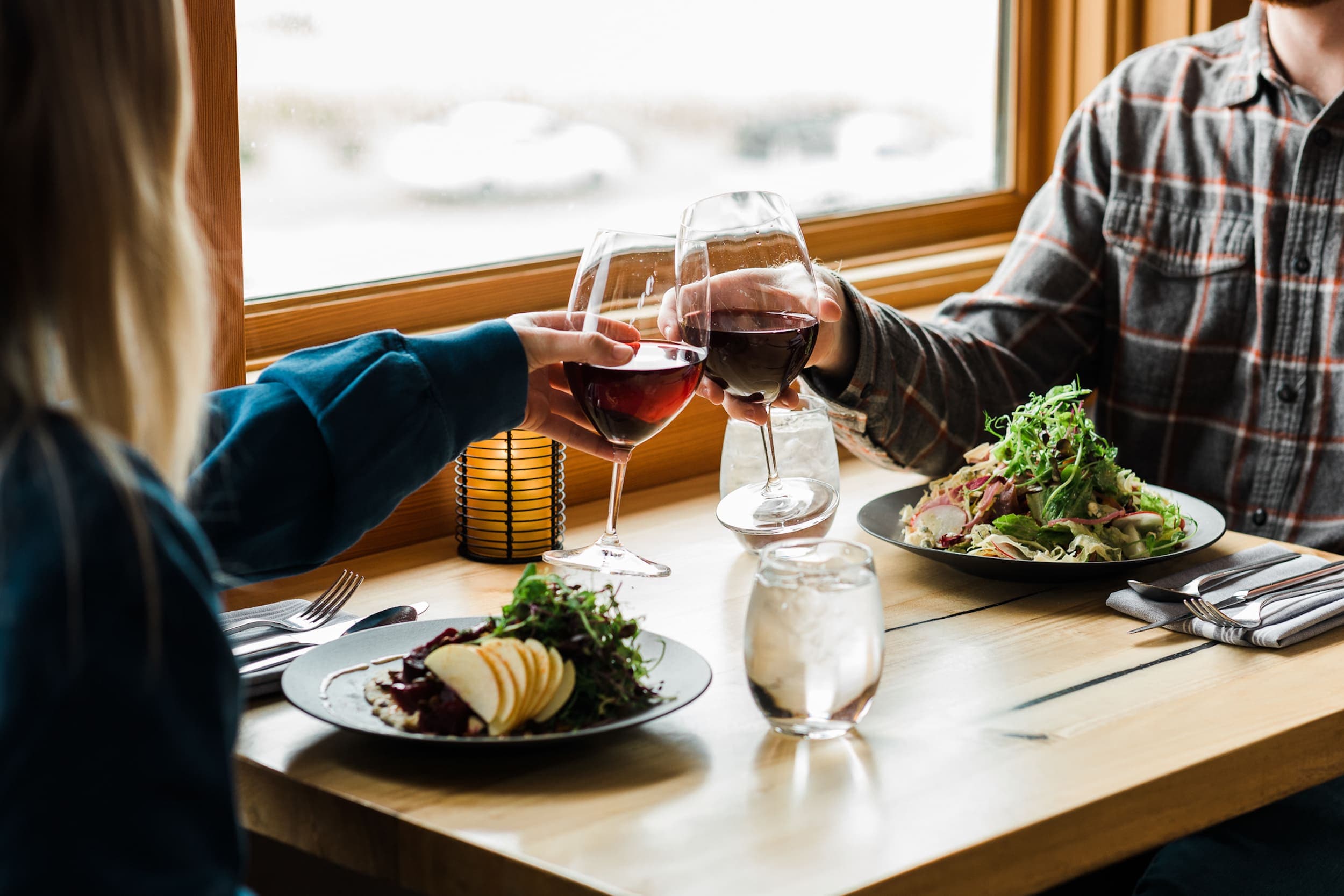 Two people eating salads and drinking red wine at Meridian Restaurant & Bar